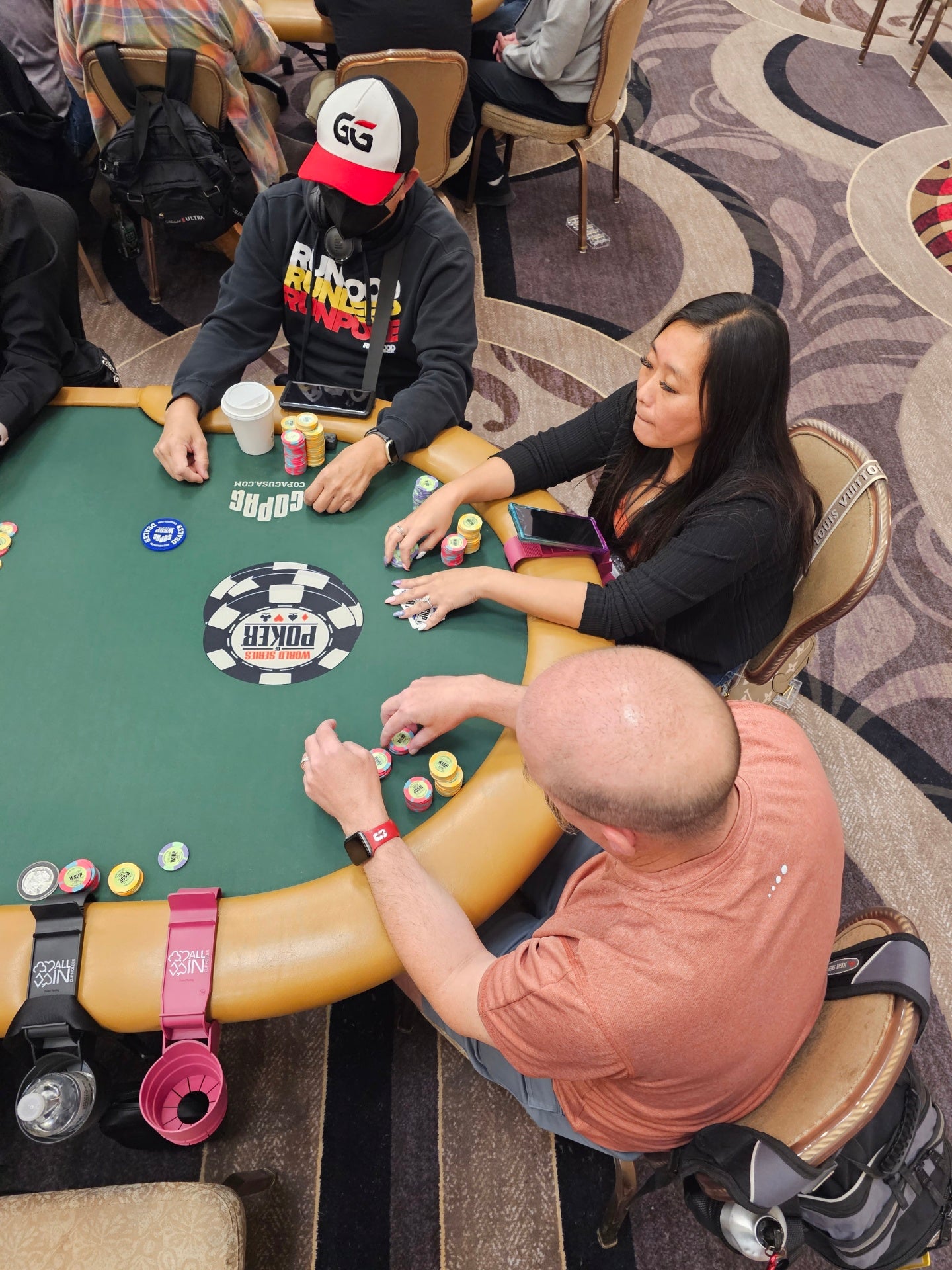 A group of pro poker players at the World Series of Poker playing with the All In Cup Holder